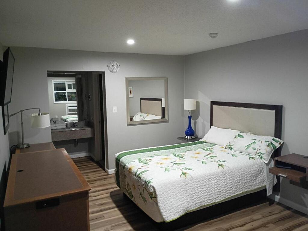 a bedroom with a bed and a desk and a sink at Bel Air Motor Lodge in Maple Shade
