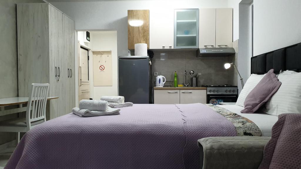a bedroom with a large bed and a kitchen at Apartman studio BMB 1 in Bukorovac