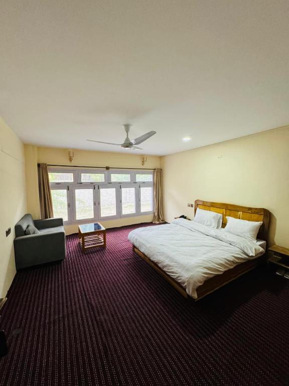 a bedroom with a large bed and a couch at Gahirat Castle Chitral in Chitral