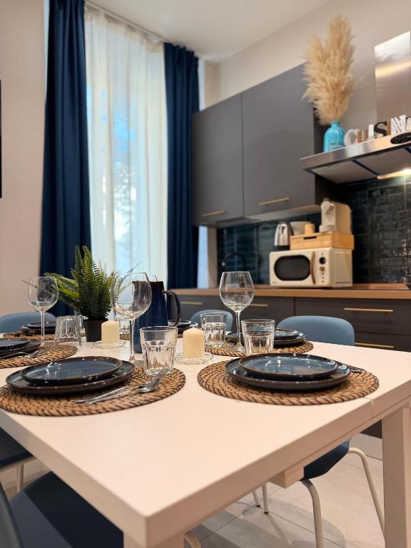 a table with glasses and plates on it in a kitchen at Bastioni Central Apartment in Civitavecchia