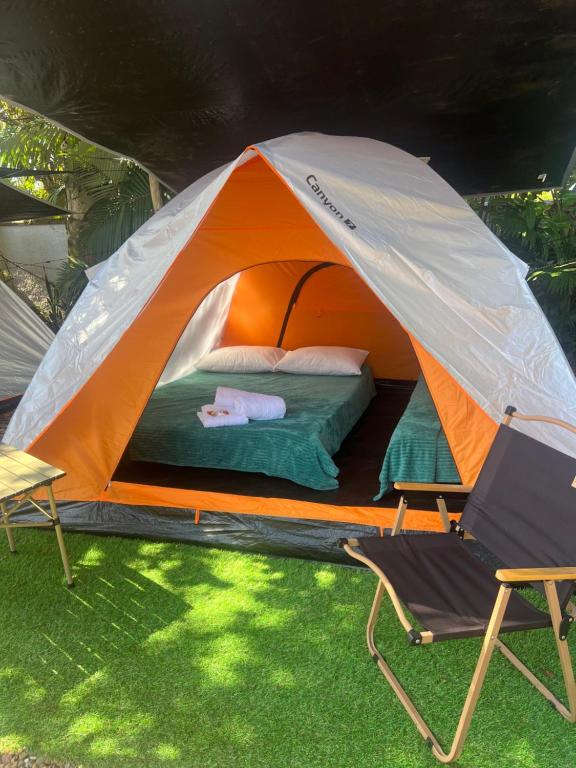 an orange and white tent with a bed and a chair at Glamping Pomerode in Pomerode