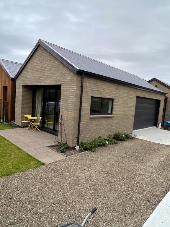 a brick house with a garage and a driveway at Charlie Browns Clyde Studio in Clyde