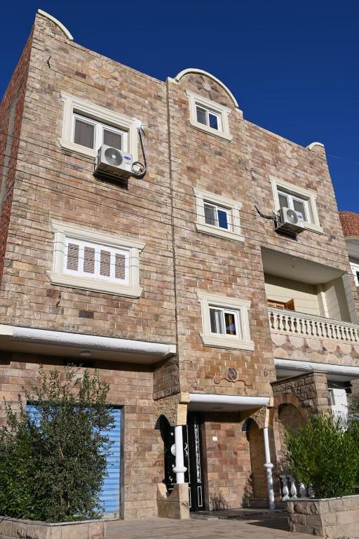 a large brick building with white windows on it at Nabo House in Abu Simbel