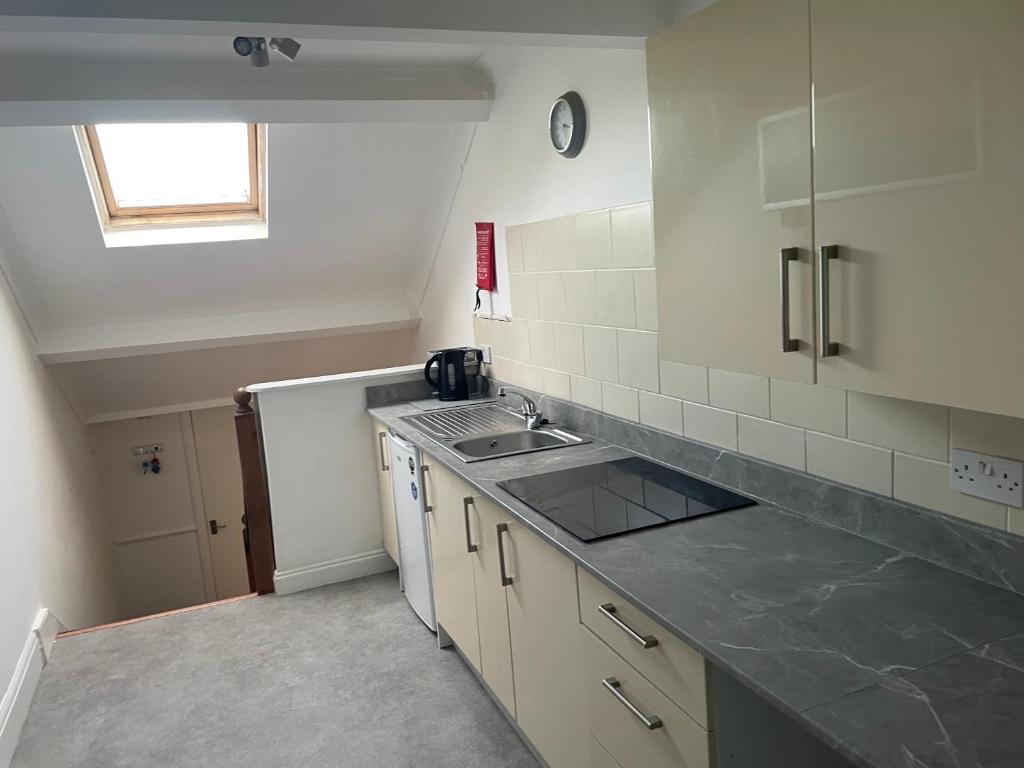 a kitchen with a sink and a counter top at Azalea apartments top floor in Sunderland