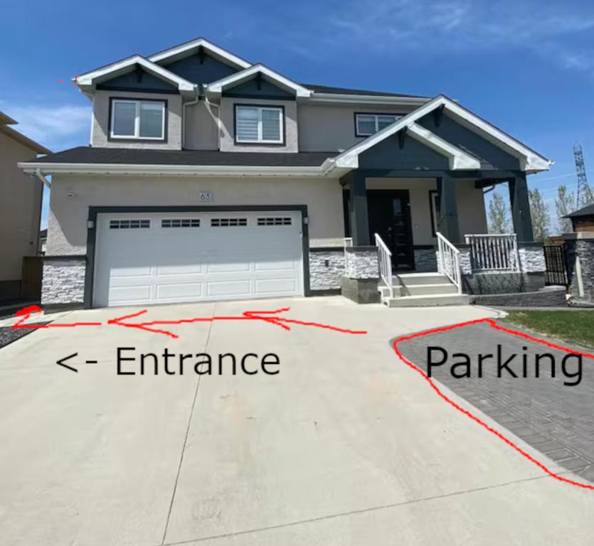 a house with a garage and a driveway with thearations at Private Entrance 2 Bed 1 Bath in Winnipeg