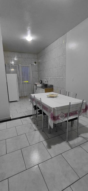 a kitchen with a table and chairs in a room at Pousada Familiar 09 in Rio do Sul