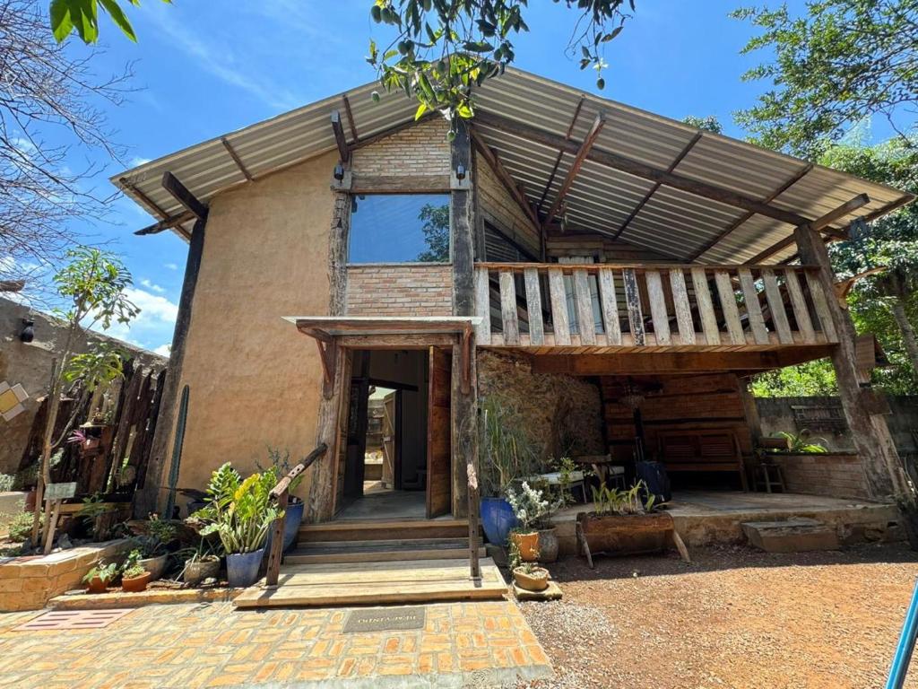 a brick house with a porch and a deck at Chalé João de barro in Bonito