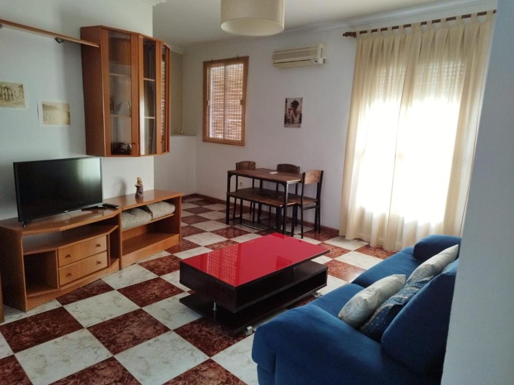 a living room with a blue couch and a tv at La Cañada in Baena