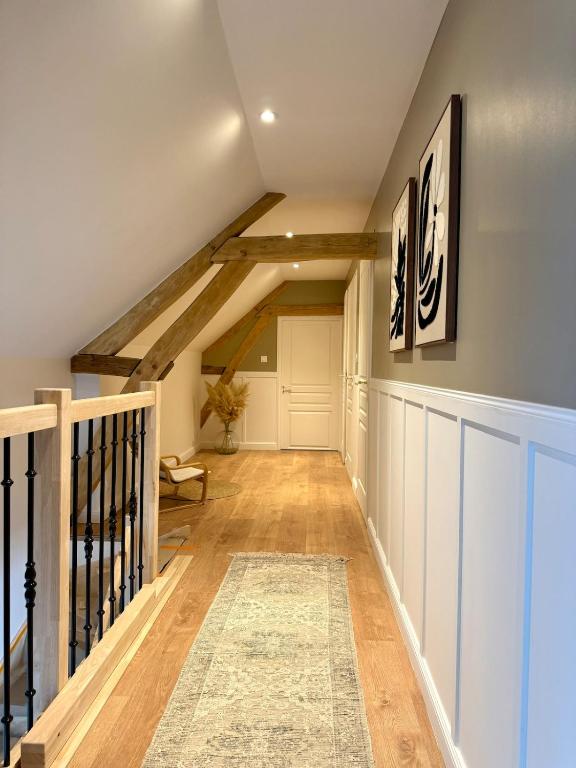 a hallway with wooden floors and a ceiling with beams at Blanche maison calme in Neuville-sur-Vanne