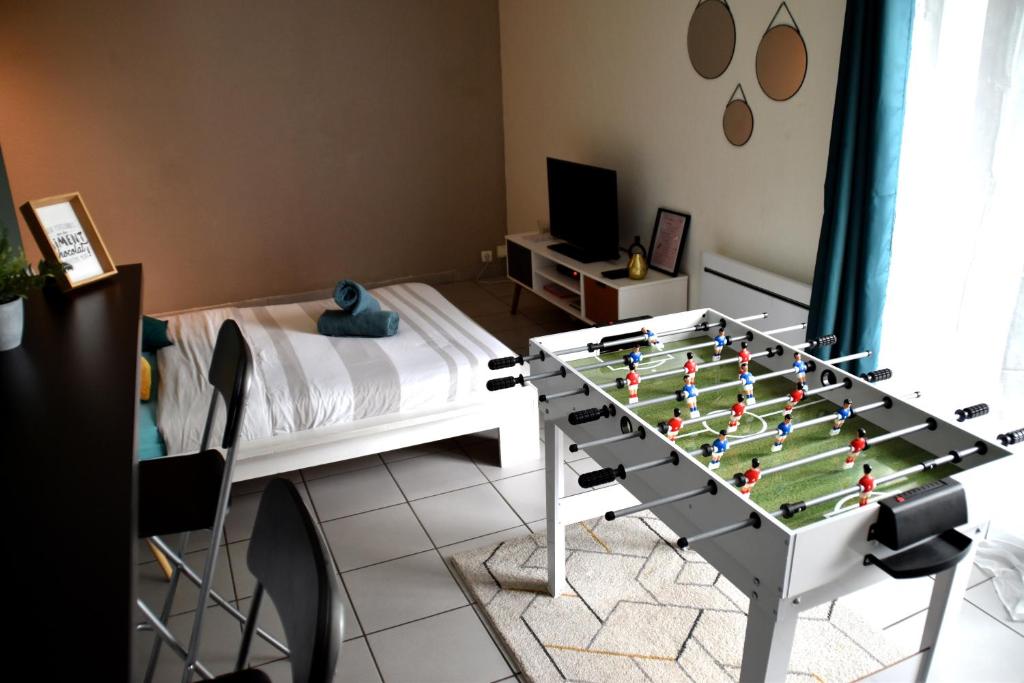 a room with a foosball table in front of a bed at La Cachette Ludique in Orléans