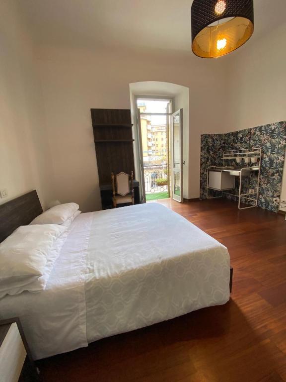 a bedroom with a large white bed and a desk at Viva Accomodation in Bergamo