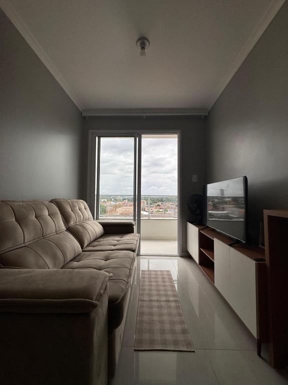 a living room with a couch and a large window at Apartamento confortável em Santarém in Santarém