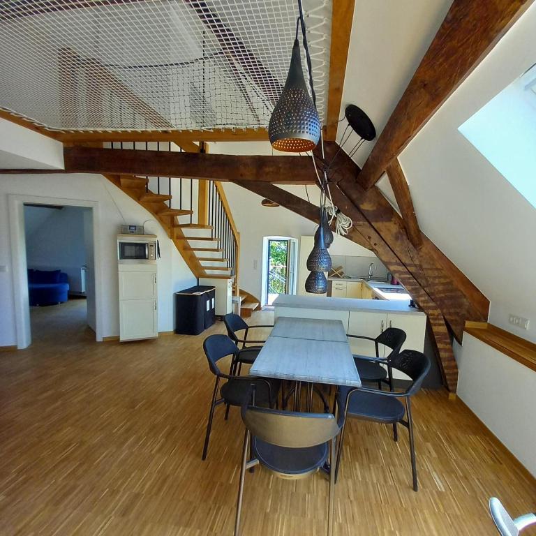 a kitchen and dining room with a table and chairs at Cosy Eco-Loft in Pettingen