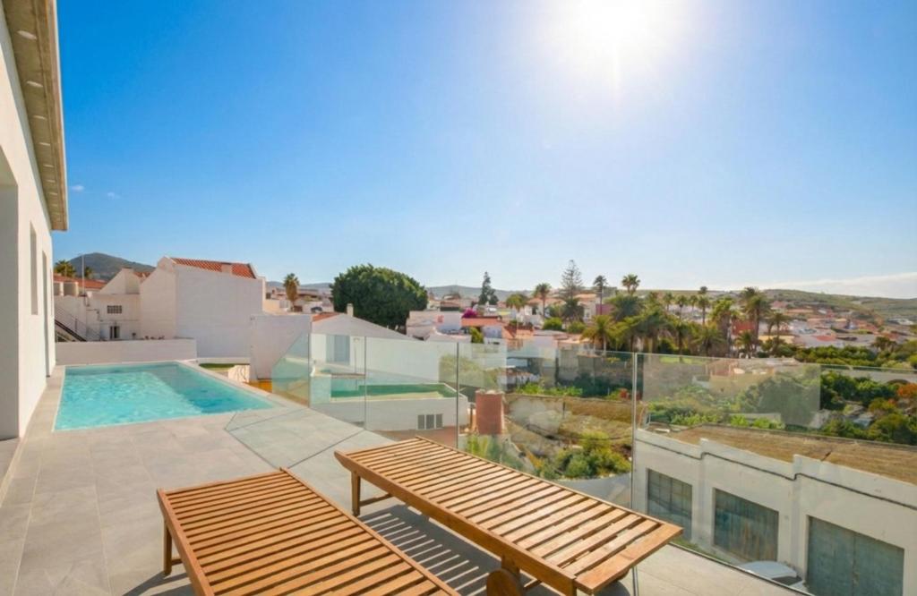 a balcony with a bench and a swimming pool at Casa Langlois in Telde