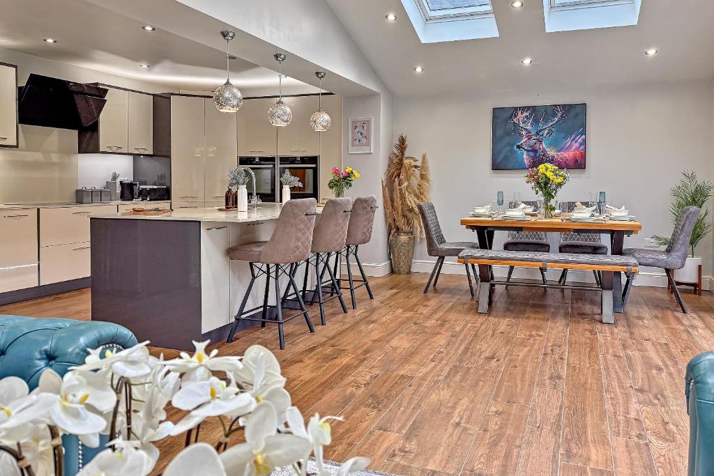 a kitchen and living room with a table and chairs at CONTRACTOR FRIENDLY-Large Driveway-THREE SMART TV's-Central Location-FOUR DOUBLE BEDROOMS in Luton