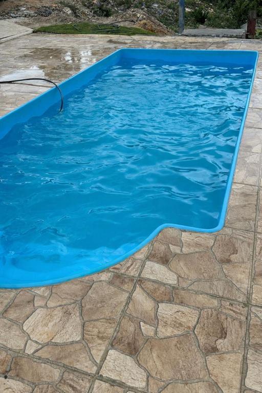 a swimming pool with blue water in a yard at Rancho Patrocínio in Patrocínio