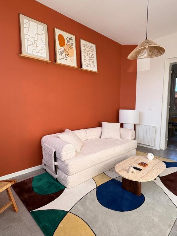 a living room with a white couch and a table at L'atelier Terracotta centre ville Bethune in Béthune
