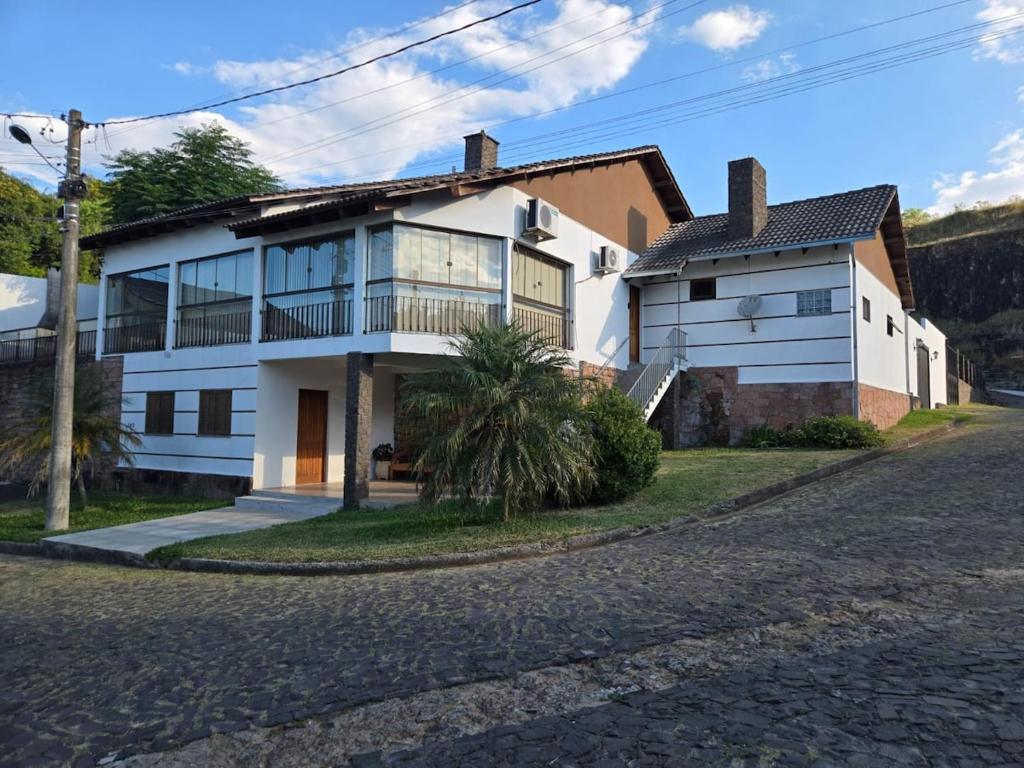 a white house with a tree in front of it at Premium house with pool in Santana do Livramento