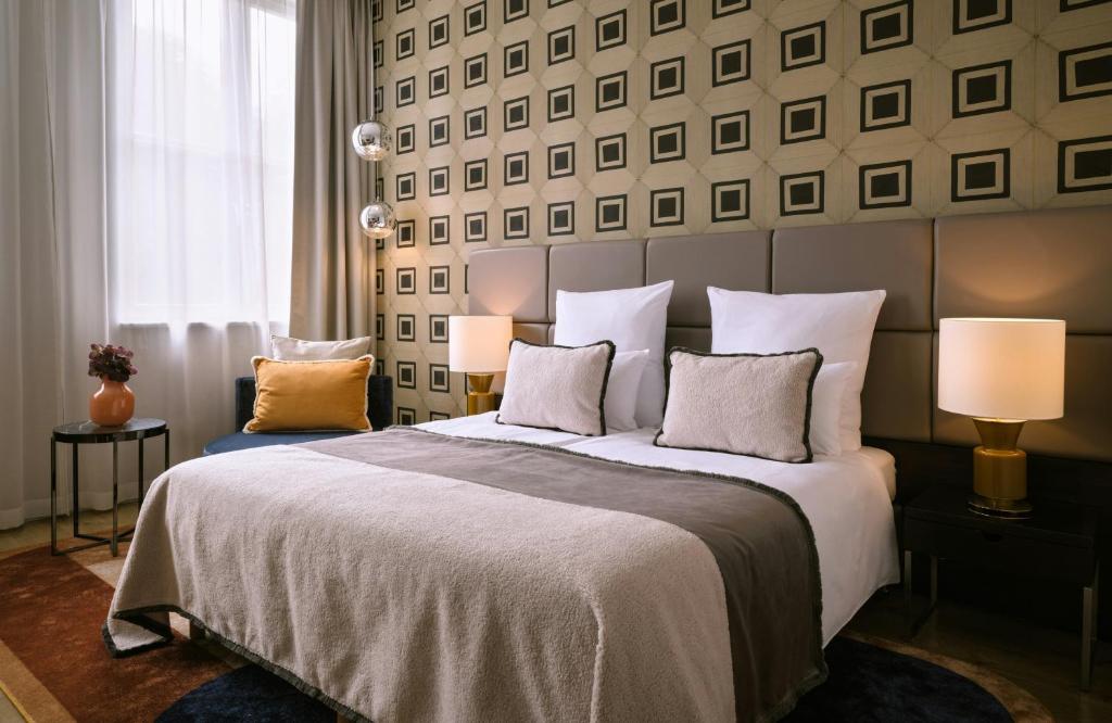 a bedroom with a large bed with two lamps at The Posthouse Berlin Potsdamer Platz- Leonardo Limited Edition in Berlin
