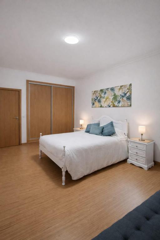 a bedroom with a large white bed and two lamps at Casa do Paraíso in Elvas