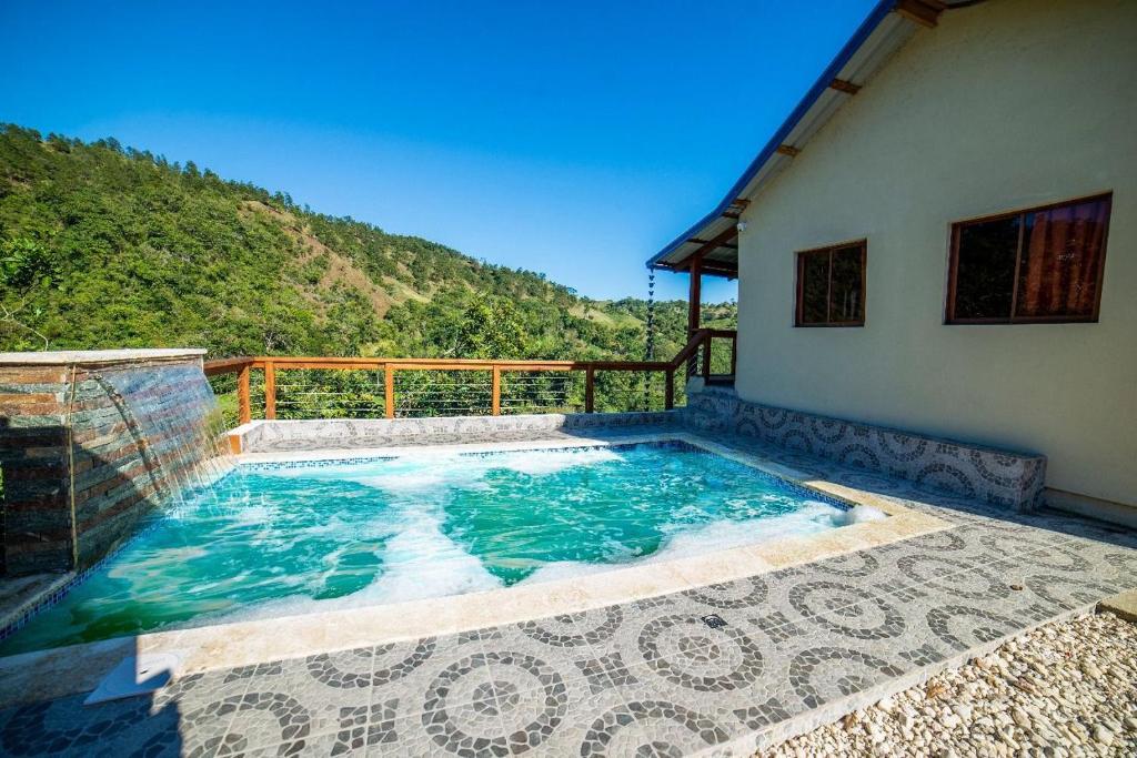 a swimming pool on the side of a house at Villa azul círculo auto in Jarabacoa