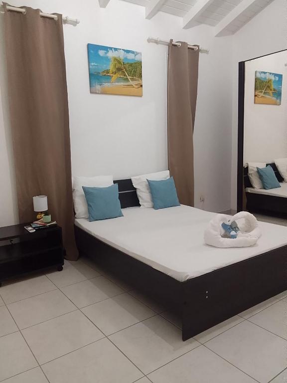 a bedroom with a large bed with blue pillows at Chambre d'hôtes du Moulin SPA in Sainte-Anne