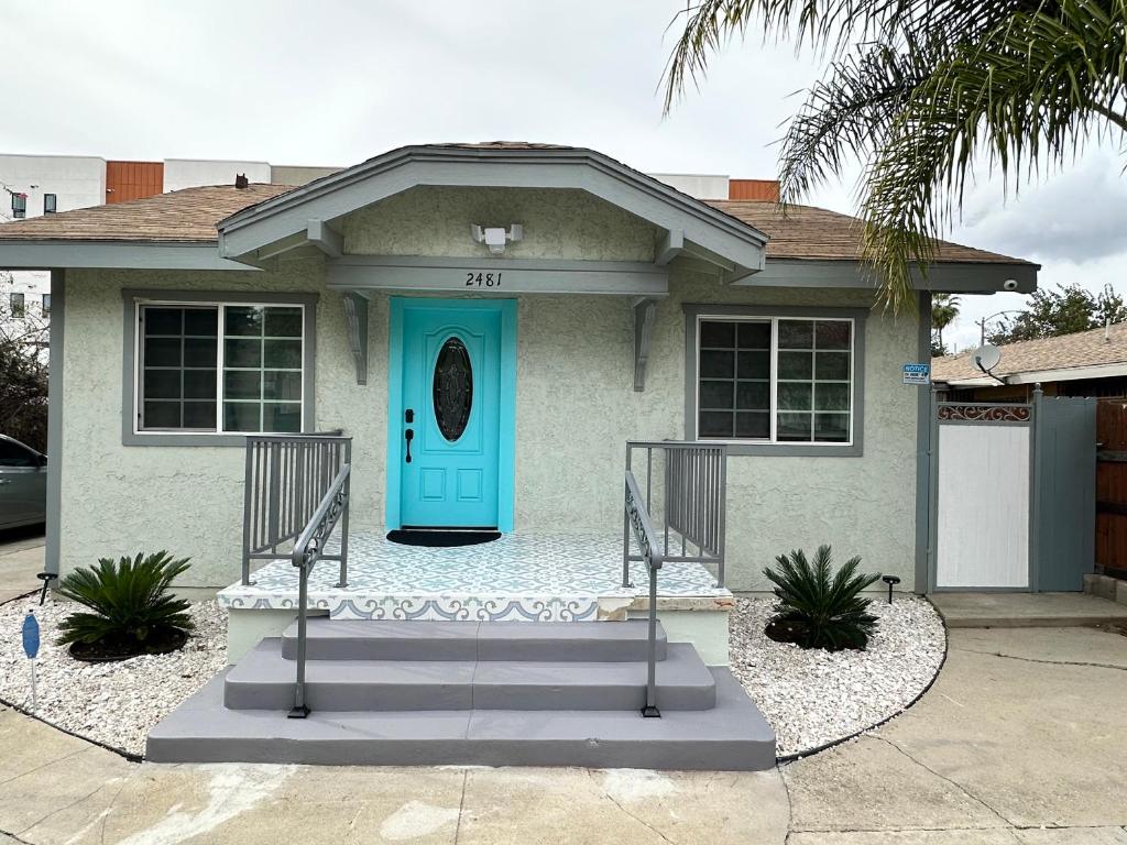 a house with a turquoise door and stairs at Coastal Calm Casita in Long Beach