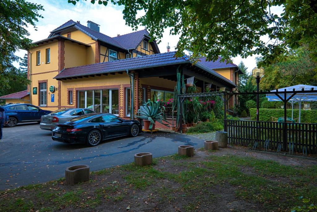 a house with a car parked in front of it at Hotel Seeschlösschen in Groß Köris
