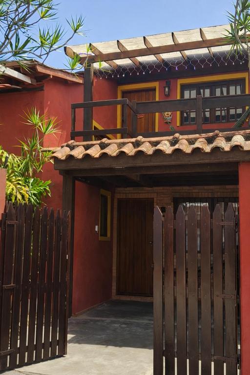 a house with a wooden gate and a fence at Chalés Ubatubaloft in Ubatuba
