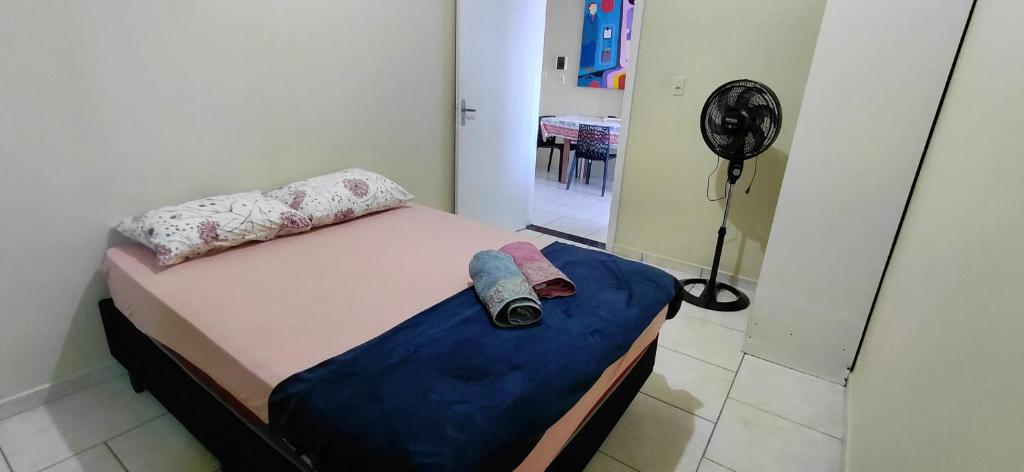 a small bed in a room with a fan at pousada Adriane in Rio do Sul