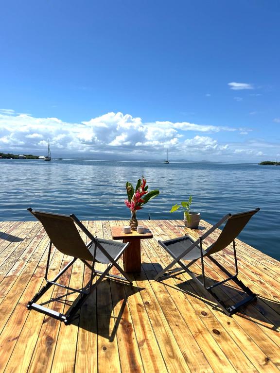two chairs and a table on a dock with the water at Blue Marlin in Bocas Town