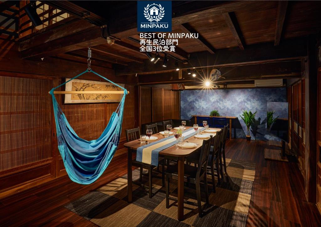 a dining room with a long table and chairs at Hinosawa Riverside Lodge 水遊び宿日野沢 in Minano