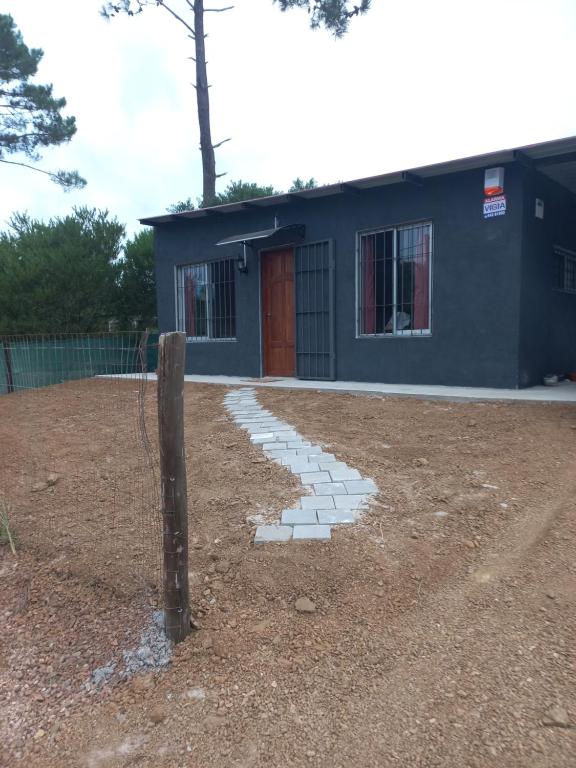 a blue building with a fence and a walkway at Grazie Carpe in Jaureguiberry