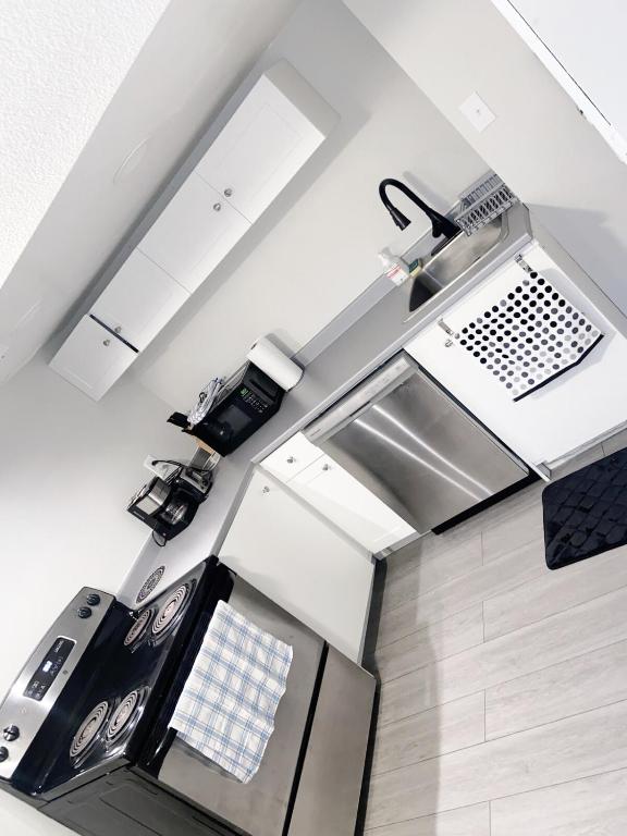 a kitchen with a sink and a stove top oven at ClassicPavillion INN in Bowmanville