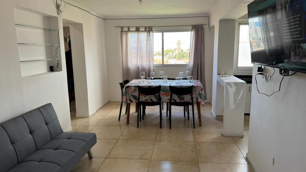 a dining room with a table with chairs and a couch at Departamento Céntrico Equipado in San Fernando del Valle de Catamarca