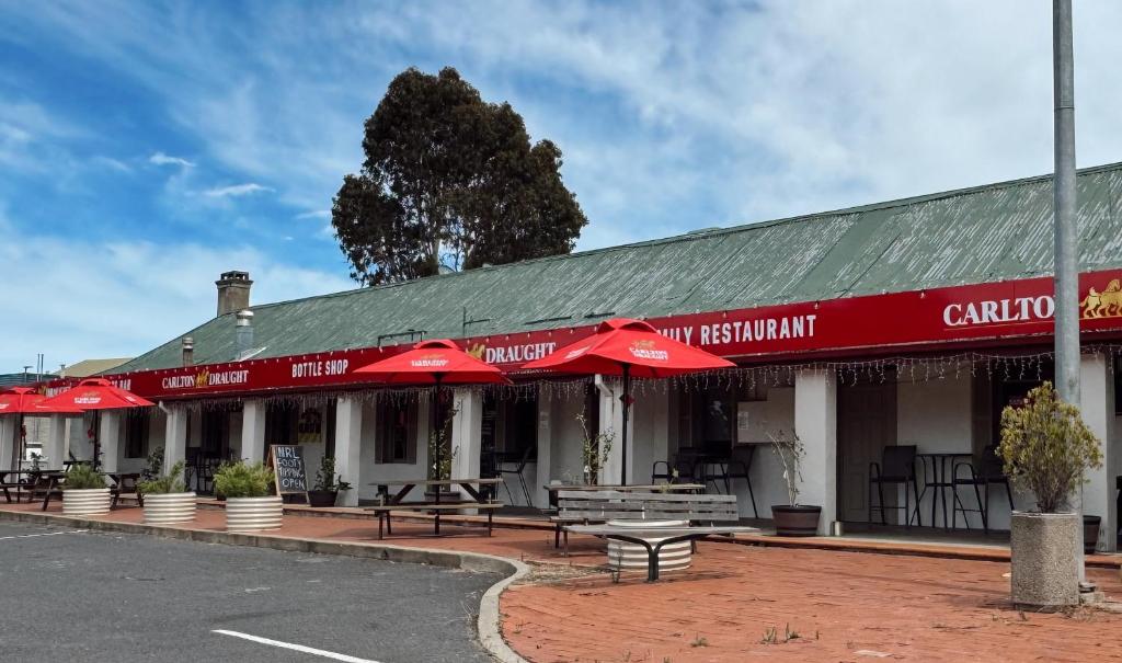 a building with red umbrellas on a street at Berridale Inn in Berridale