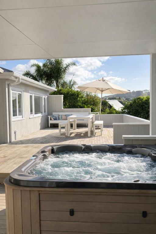 a hot tub in the backyard of a house at Lukes Kitchen Bach in Kuaotunu