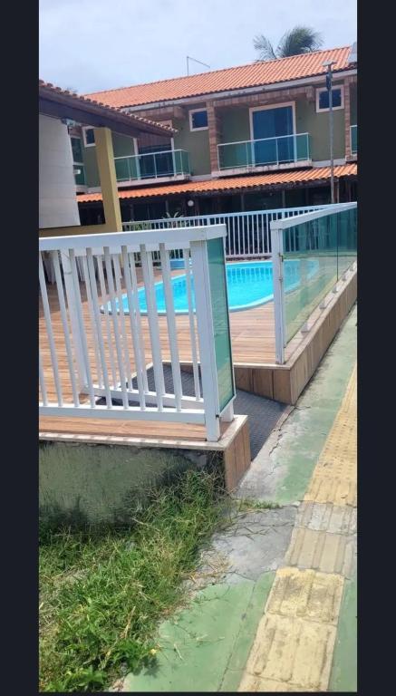 a wooden bench next to a swimming pool at LardoceLar in Camaçari