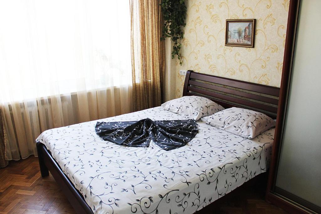 um quarto com uma cama com lençóis e almofadas pretas em Apartments on Pechersk em Kiev
