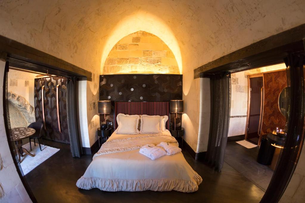 a bedroom with a bed with two towels on it at HSVHN Hotel Hışvahan in Gaziantep