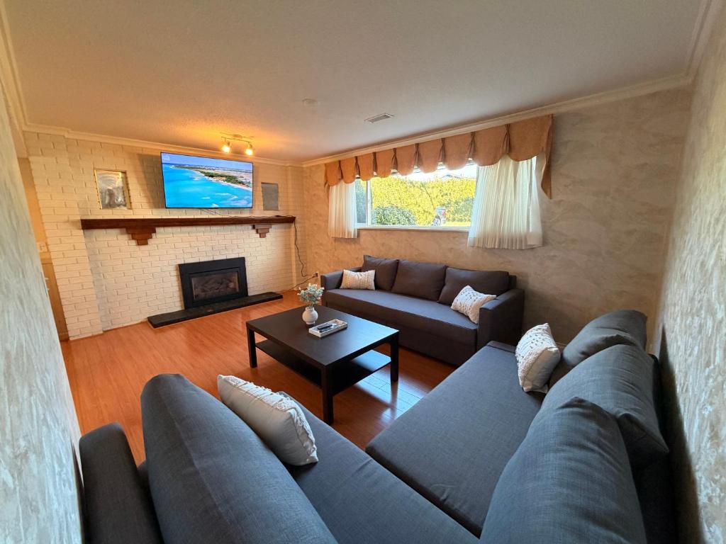 a living room with a couch and a fireplace at Spacious 2 Bedroom Suite in Delta