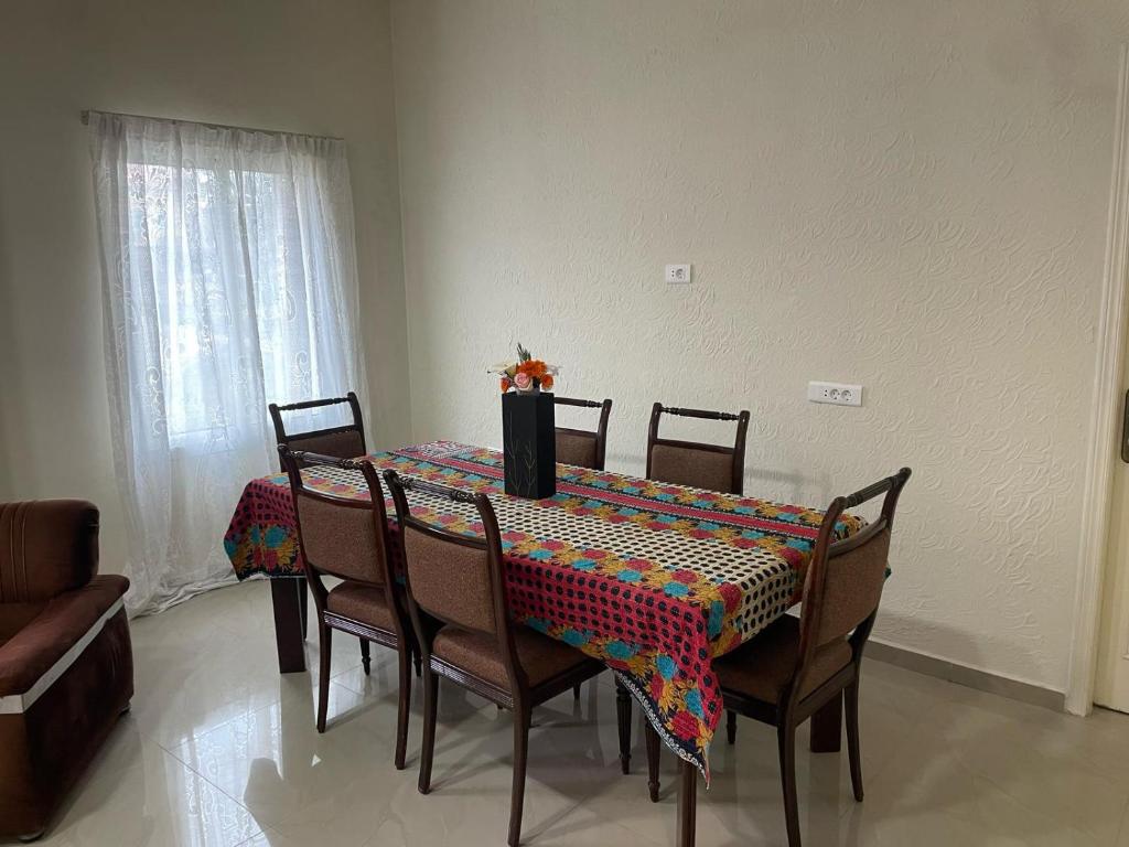 a dining room table with a colorful tablecloth on it at beit al moukhtar in Ḩārat at Taḩtā
