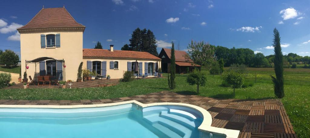 a house with a swimming pool in front of a house at La Rolandie Haute in Limeuil