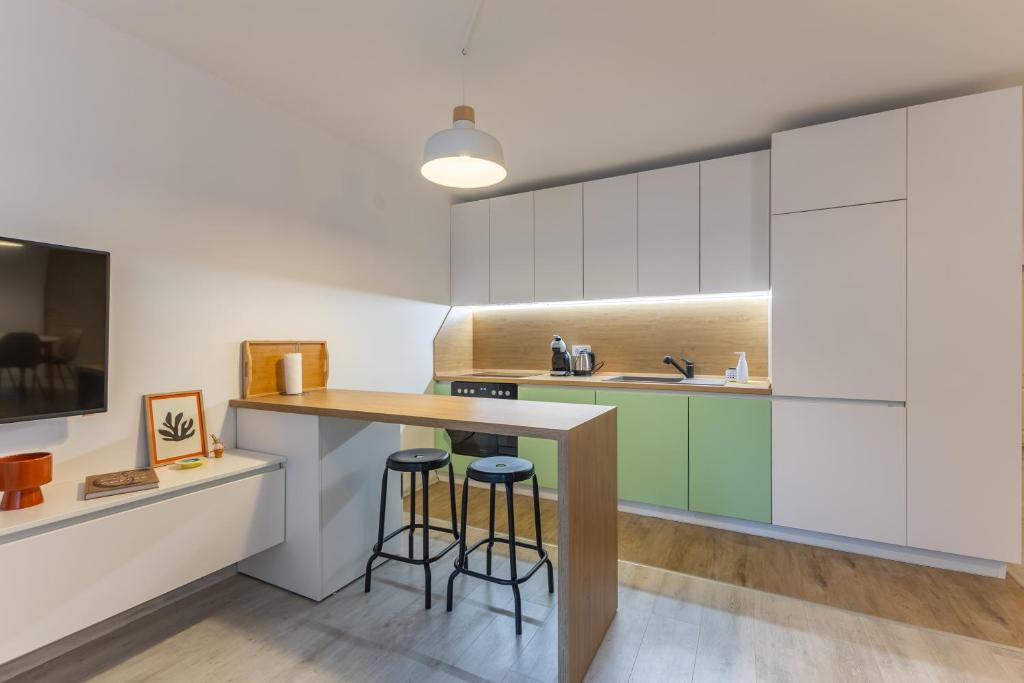 a kitchen with white cabinets and bar stools at Central 2BR - Workspace with Elevator in Varna City