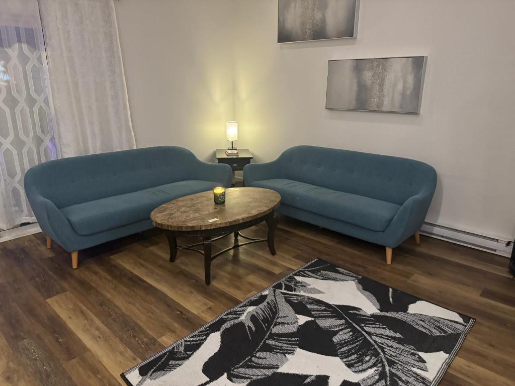 a living room with two blue couches and a table at Next rental in Vernon