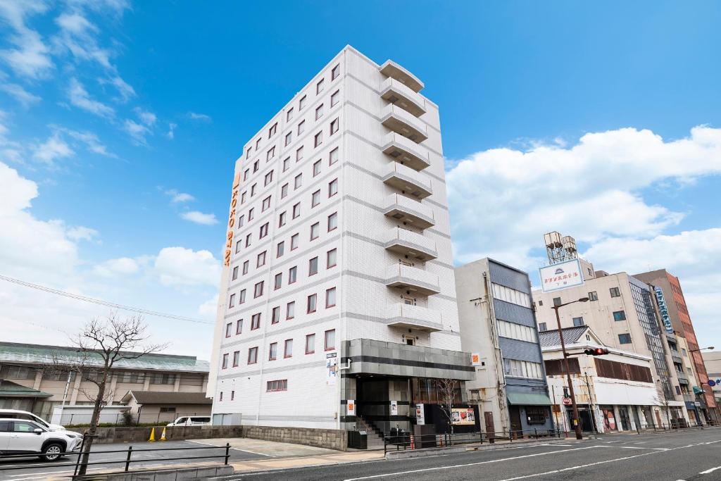 a tall white building on a city street at KOKO STAY Shimonoseki in Shimonoseki