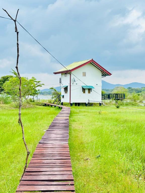 a wooden path leading to a white house at LEOPARD One Villa in Gotamegama