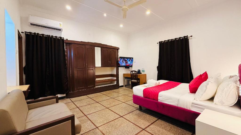 a bedroom with a bed and a couch and a tv at Sun Stayz Inn T - Nagar Chennai in Chennai