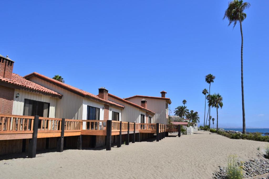 a row of houses on a beach next to the ocean at Hotel Quintas Papagayo in Ensenada