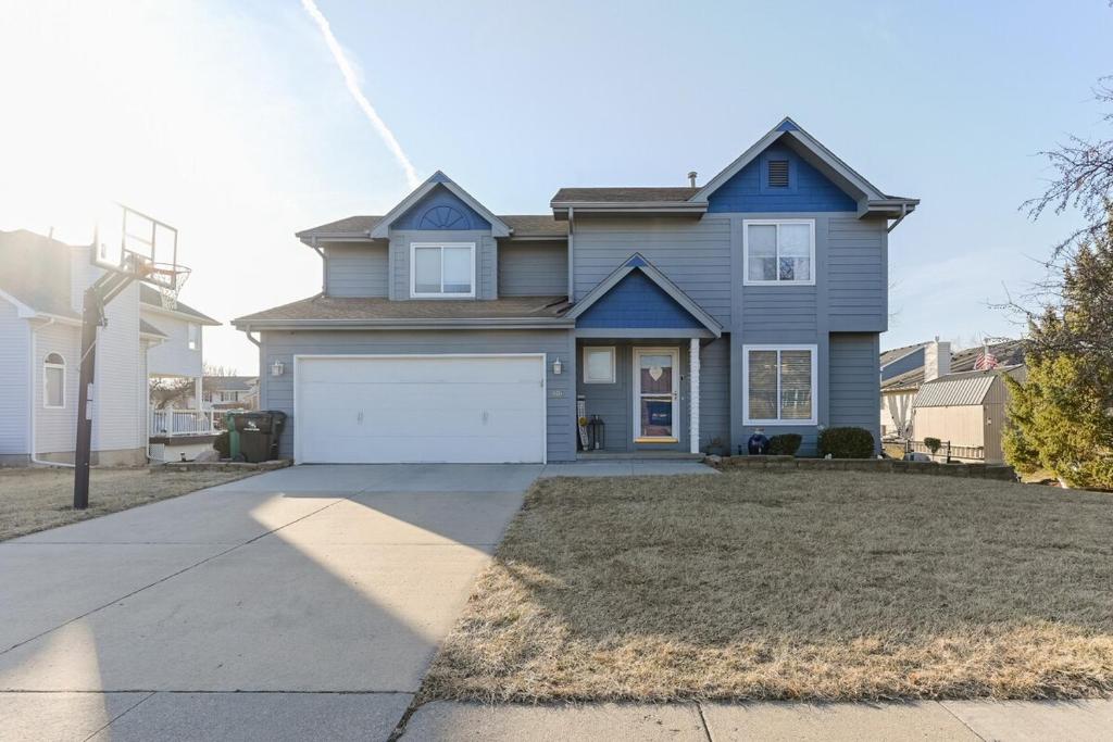 a blue house with a white garage at Heart & HomeStay in Ankeny